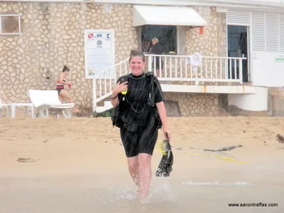Diane Traffas walks in the rain from the SCUBA desk to the boat